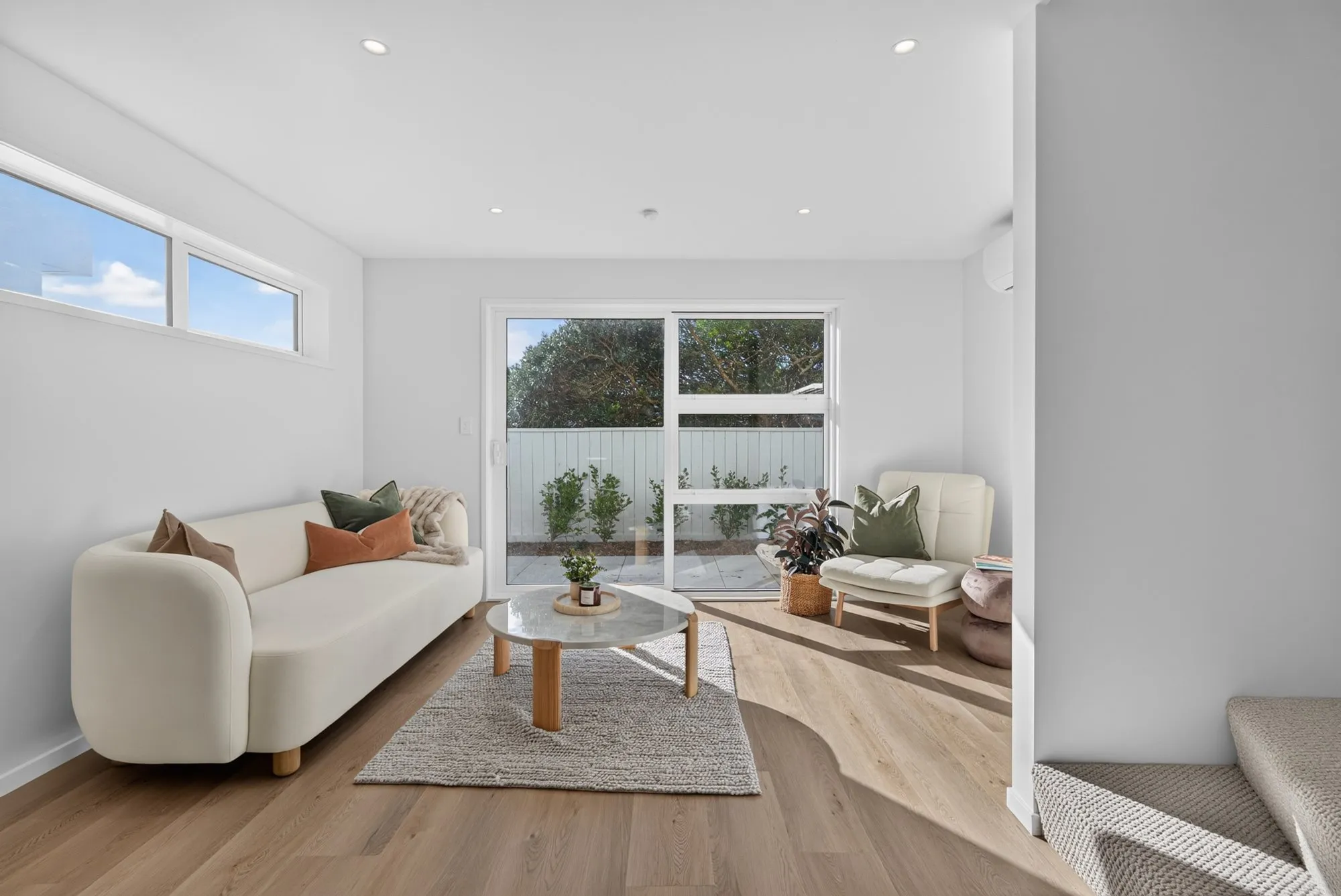 Furnished open plan living room with light timber floors