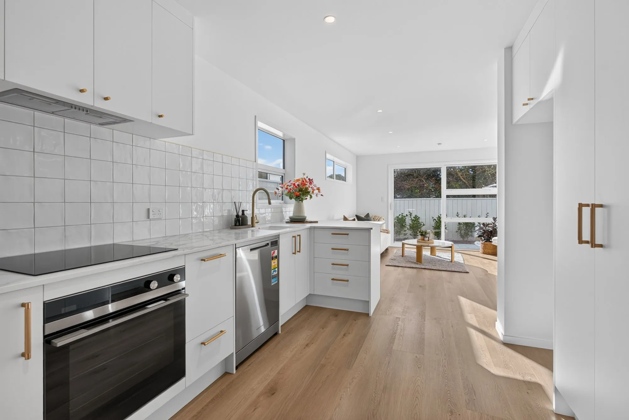 Kitchen with white cabinetry and brushed gold tapware