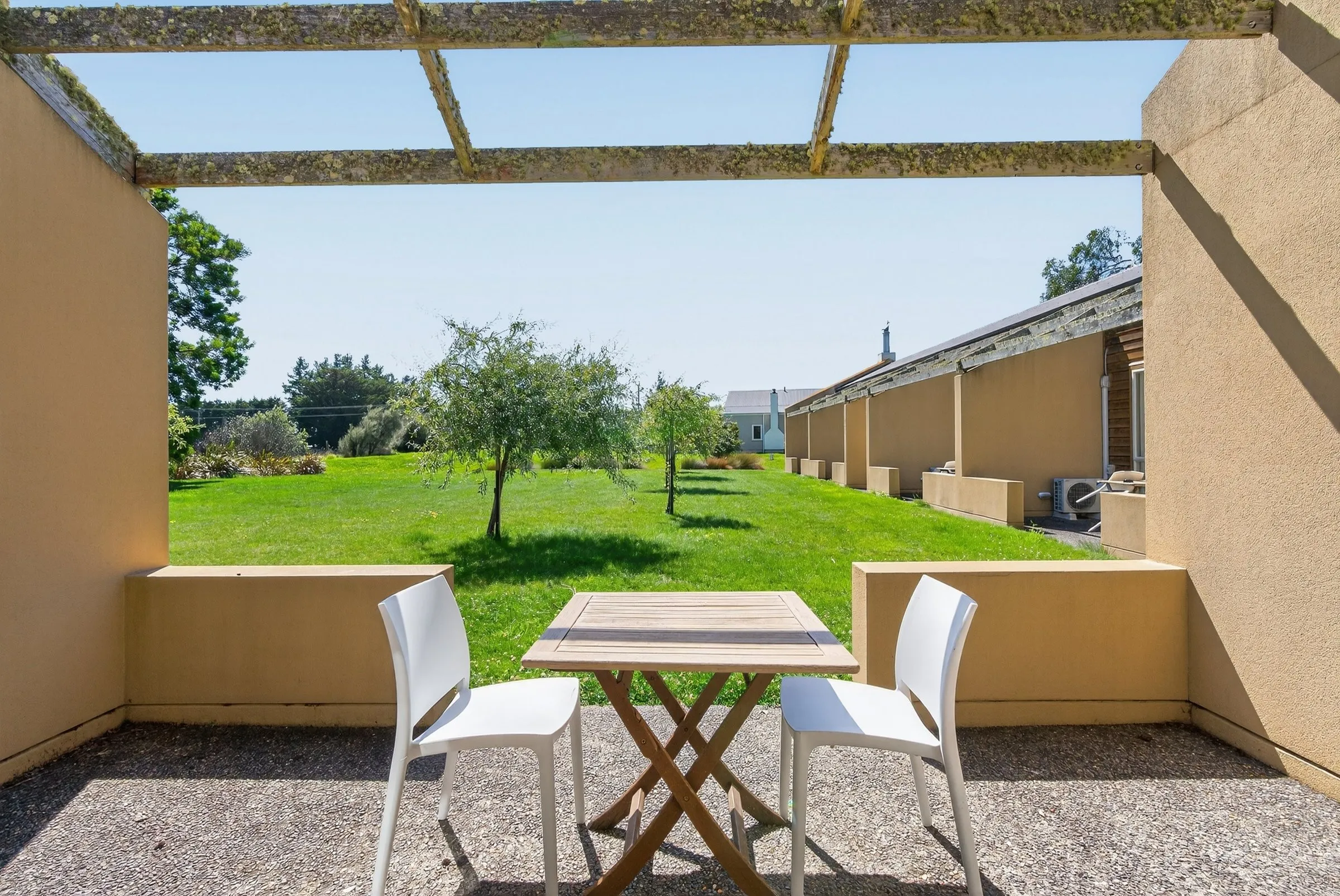 Covered verandah with outdoor dining looking out over the lawn