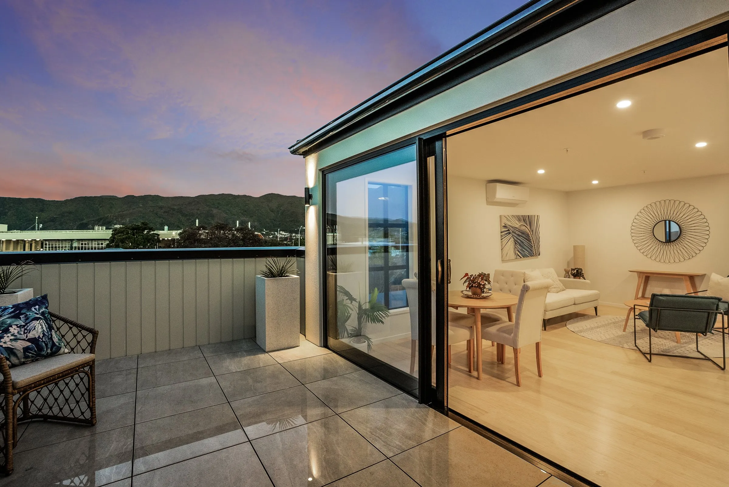 A private deck at dusk opening to the living area