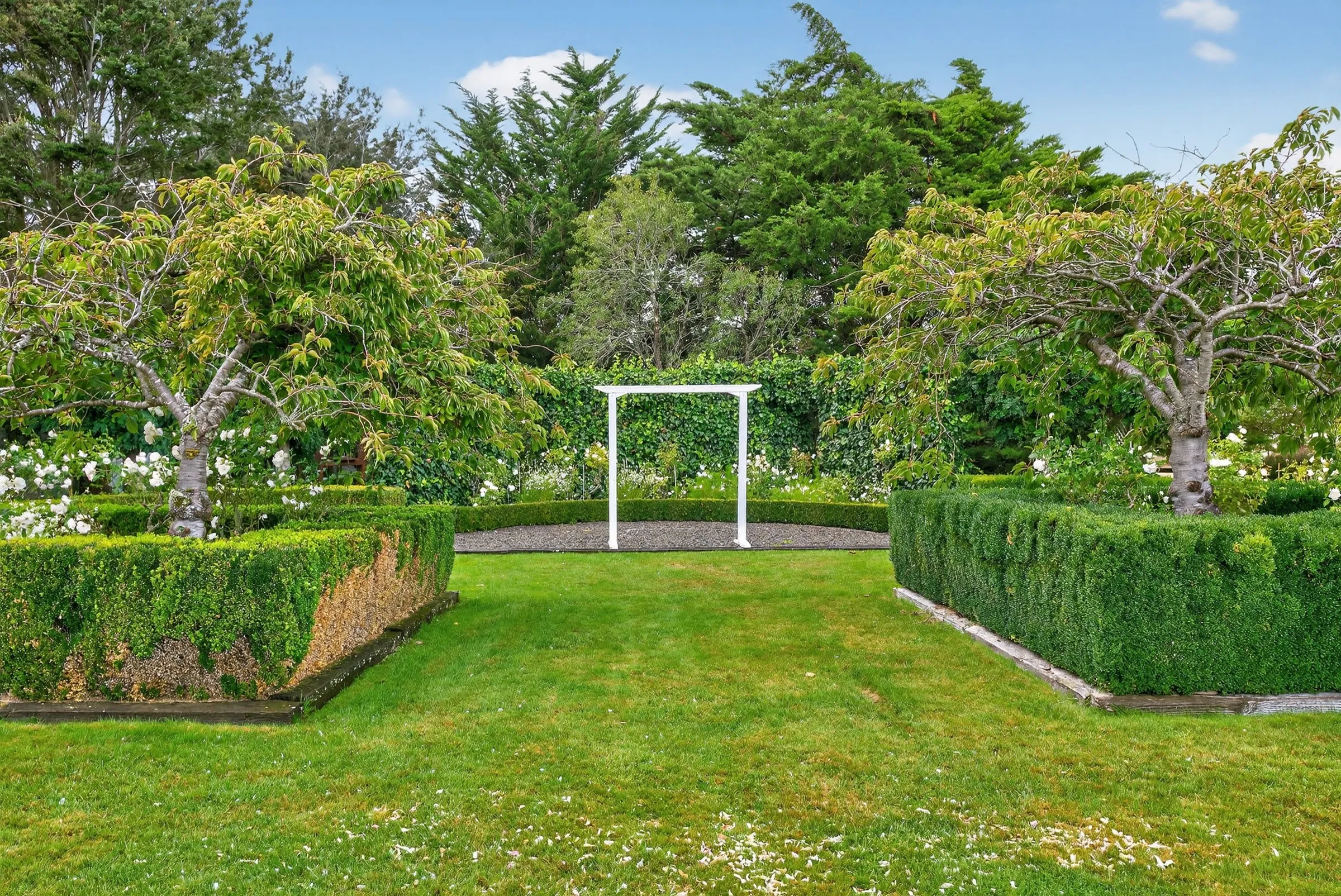 Established gardens with a white arbour