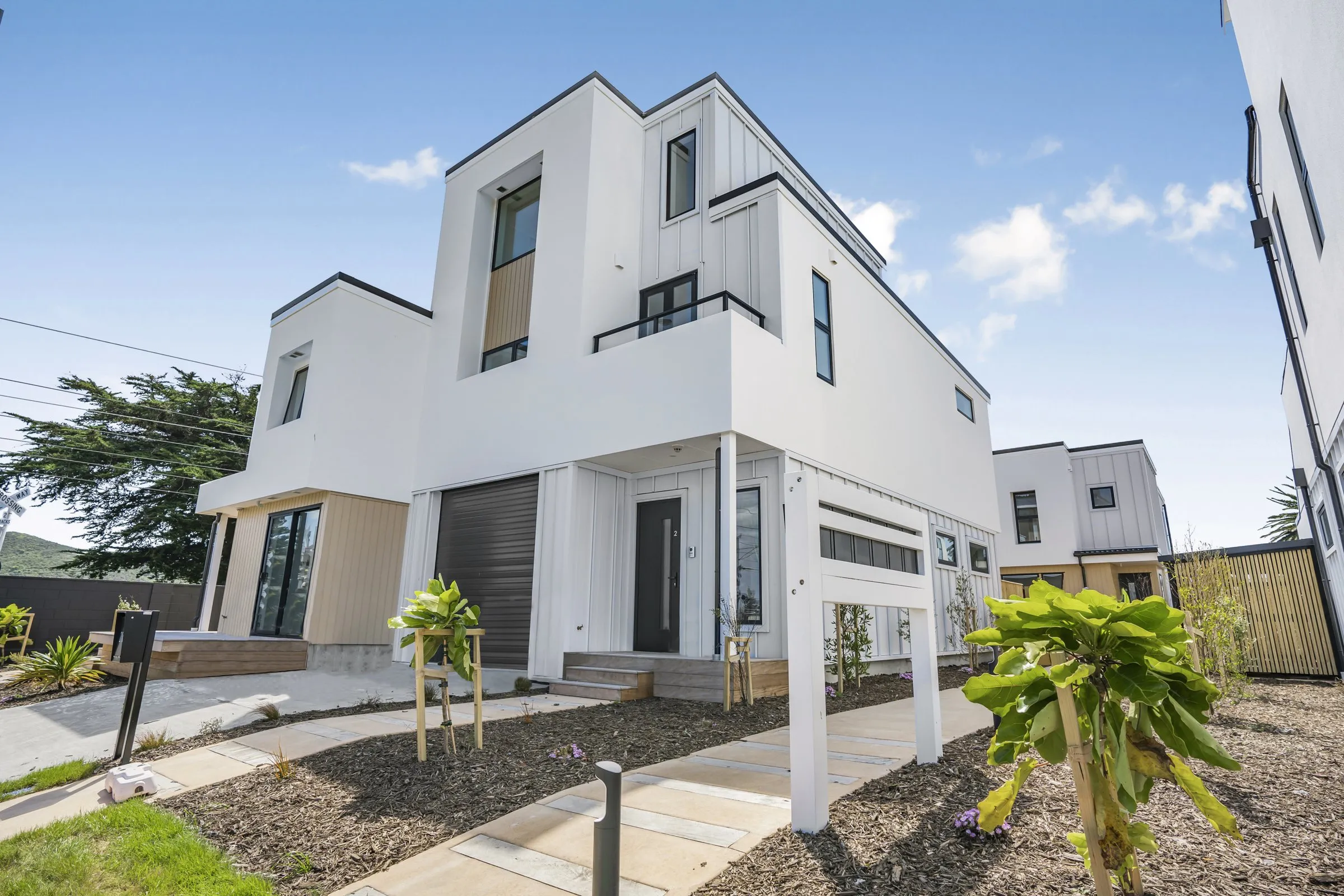 The Marina, new two storey townhouses in Mana under a blue sky